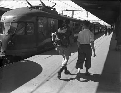 804210 Afbeelding van twee treinreizigers op het perron van het N.S.-station Eindhoven te Eindhoven, met een electrisch ...